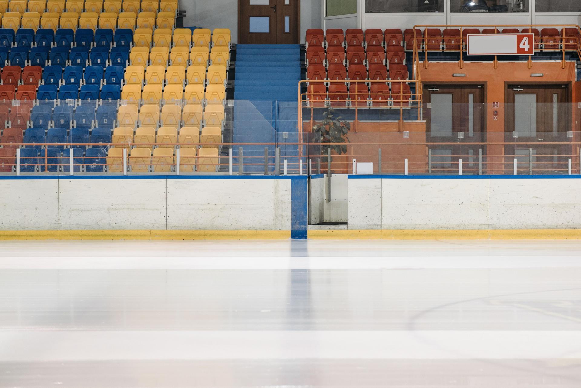 Empty ice hockey rink with colorful bleacher seating